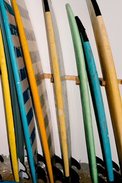 Surfboards arranged on a rack inside a surf equipment storage room