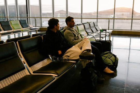 Friends sitting with suitcases in an airport waiting area in Morocco