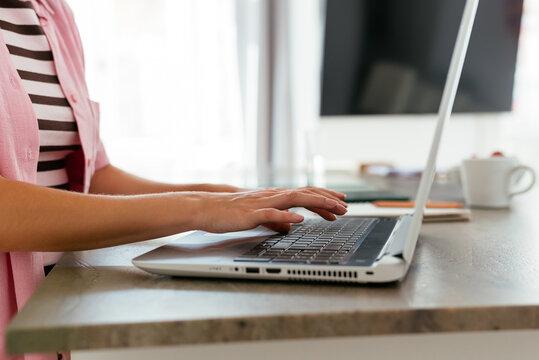 Anonymous young woman using laptop