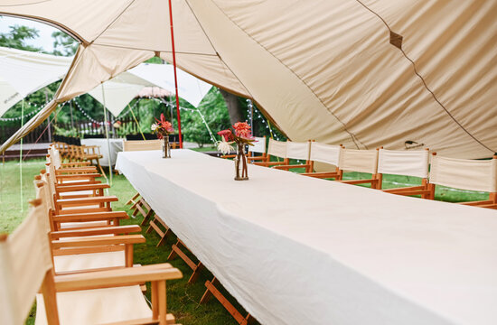 Closeup of a large dining table set up on a rural outdoor lawn