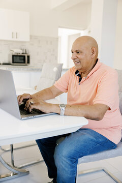 Man Working on Laptop in Bright Home Office During the Day