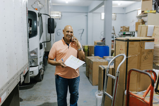Man Walks Through Warehouse While Talking on Phone