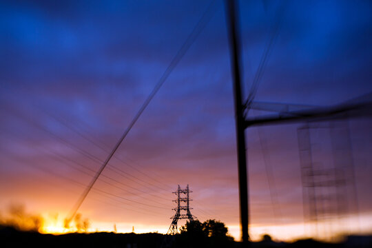 Abstract power lines and electrical towers at sunset