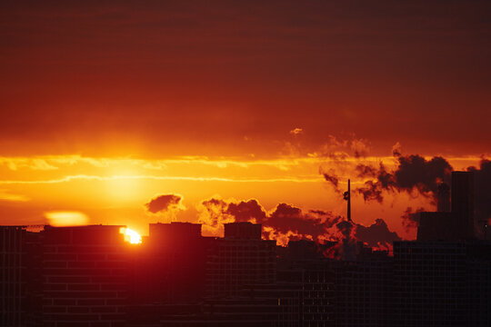 Sunset over city skyline with clouds and warm colors