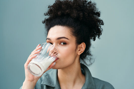 Woman Enjoys a Refreshing Drink While Relaxing in a Cozy Space
