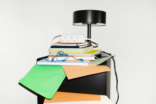View of office desk with lamp, colourful papers and office tools 
