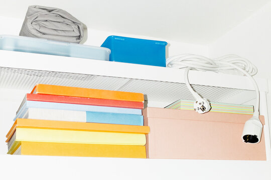 A shelf filled with colourful everyday life objects with flashlight