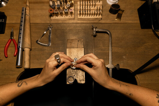 Jeweler is polishing workpiece with hand file
