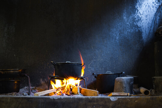 Cooking on an open fire in a poor kitchen with pots and flames