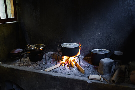 Cooking on an open fire in a poor kitchen with pots and flames