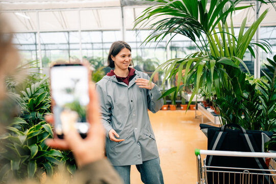 Person Talking in a Greenhouse With Plants and a Phone Nearby