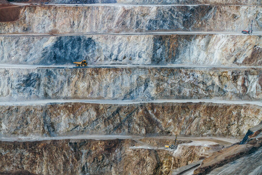 Heavy machinery operating on stepped quarry wall