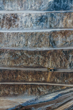 Vertical quarry terraces with haul truck in operation