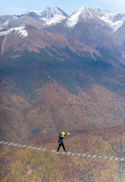 Adventurer crosses suspension bridge over snowy abyss 