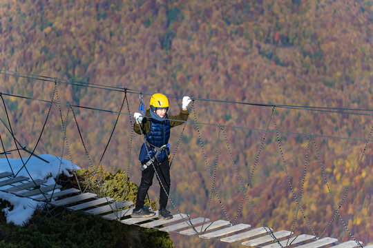Adventurer crosses suspension bridge over snowy abyss 