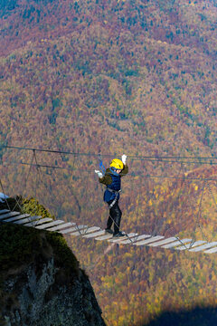 Adventurer crosses suspension bridge over snowy abyss 