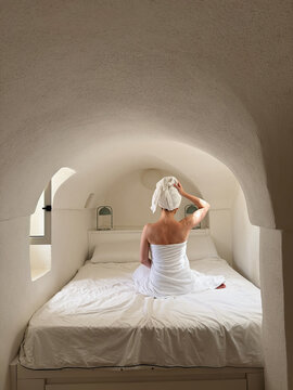 Woman after shower sitting on the bed.