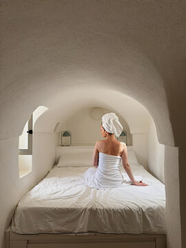 Woman after shower sitting on the bed.