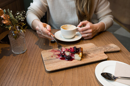 Enjoying Basque Cheesecake and Coffee at a Cafe 