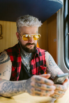 A man uses a mobile phone while sitting on a train.