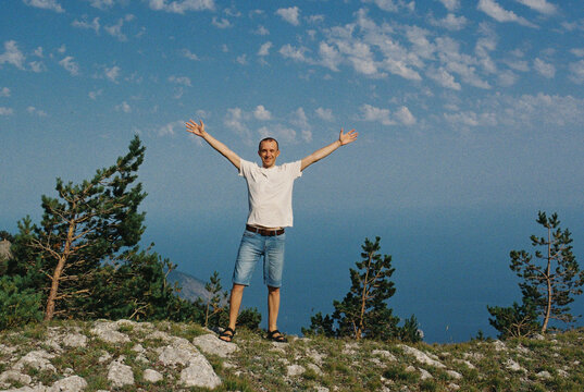 Happy smiling man at mountains at summer.