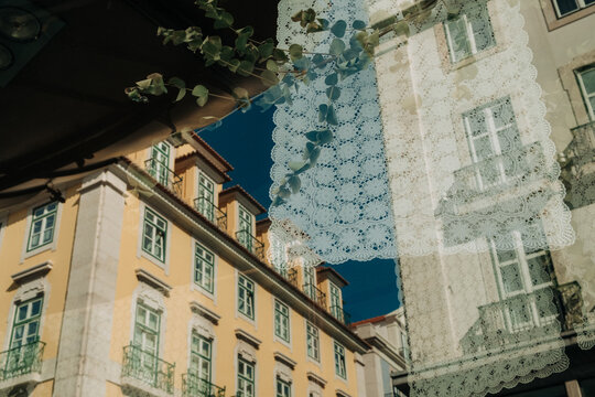 Lace curtain with city reflection in window