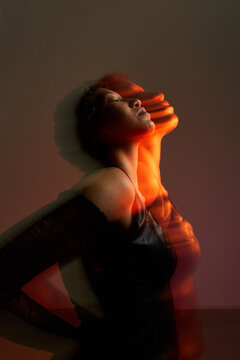 Woman in motion with colorful light effects at indoor setting