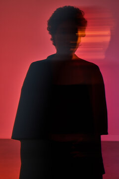 Mysterious figure in dynamic light setting at art studio