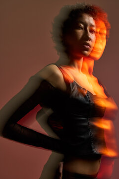 Model posing in studio with creative lighting and blurred effect