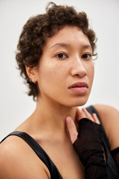 Model poses indoors with short curly hair during studio session