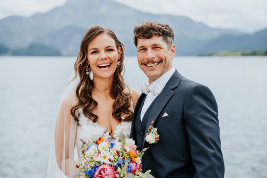 Laughing bride and groom during lakeside wedding