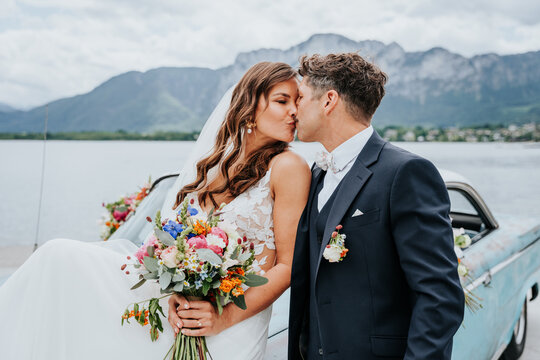 Bride and groom kissing at lakeside wedding in Austria