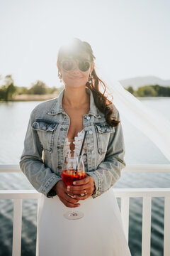 Relaxed bride portrait with sunglasses and cocktail at destinati