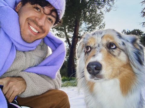 Man posing with dog outdoors in snowy park