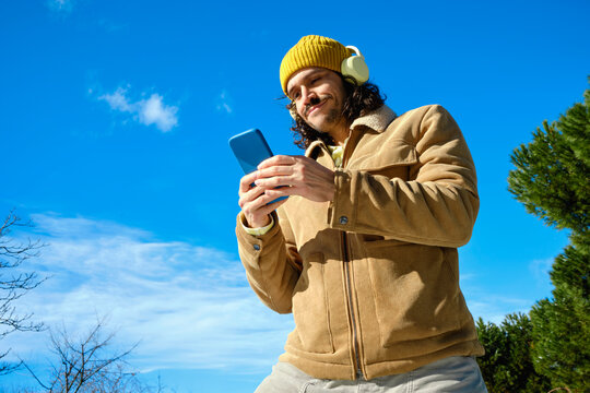Man using smartphone outdoors in winter clothing