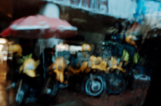 Bikers Waiting Under Umbrella During Rainy Day in the City