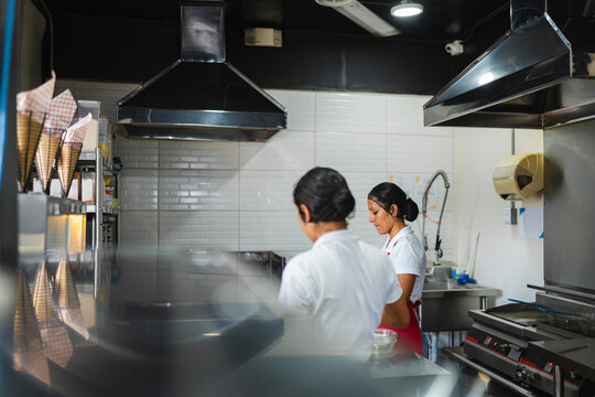 Two female chefs working hard in a modern professional kitchen