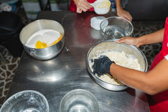 Female chefs mixing flour, sugar, and butter in professional kitchen