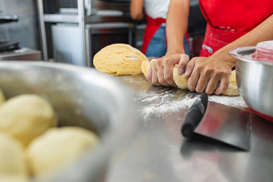 Cook kneading portion of dough and ready balls in the foreground