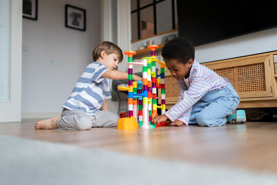 Diverse children playing colorful marble run toy