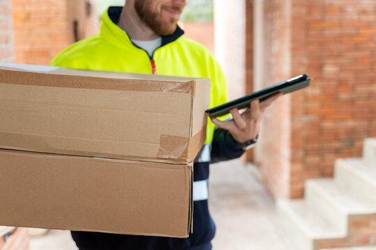 Courier carrying packages using tablet device