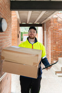 Delivery worker holding packages at entrance