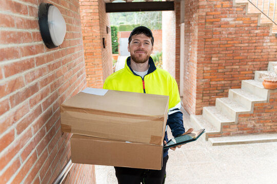 Delivery worker holding packages at entrance