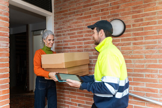 Delivery Worker Hands Over Packages to Woman at Her Home