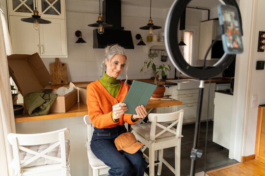 Senior woman recording fashion vlog

