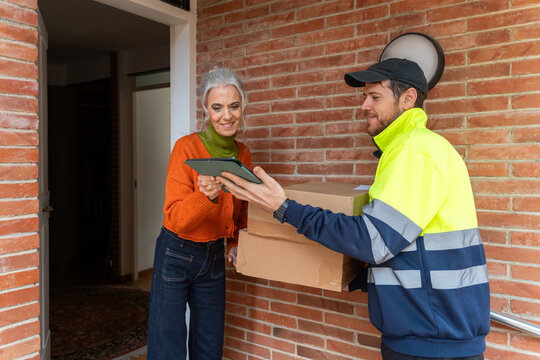 Courier delivering packages to senior woman
