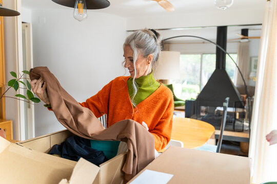 Happy senior unboxing clothes