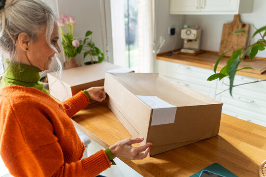 Senior woman unboxing package
