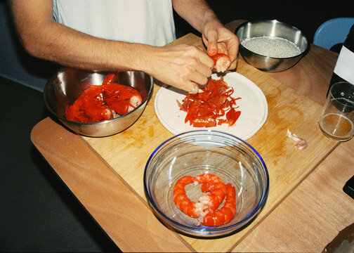 Analog shot of an anonymous person peeling shrimp