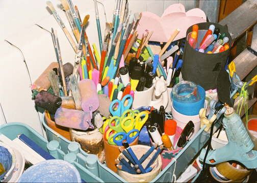 Messy shelf lit by flash, filled with items for painting